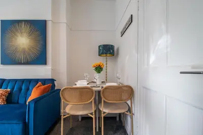 a dining room with a blue couch and a table with chairs at Bella House - 3 bed house in Glasgow in Glasgow
