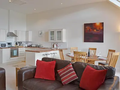a living room with a couch and a kitchen at The Quaich in Stron-fearnan
