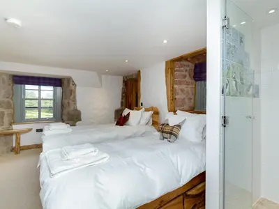 a bedroom with two beds and a shower at Knock Old Castle in Largs