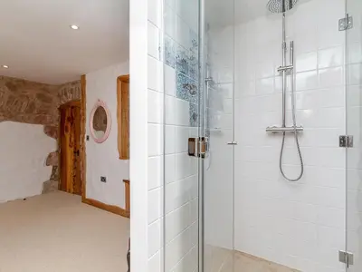 a shower with a glass door in a bathroom at Knock Old Castle in Largs