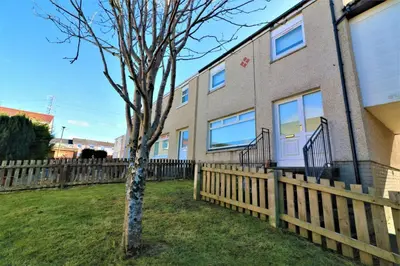 a building with a wooden fence next to a tree at Signature - Honeywell House in Chapelhall