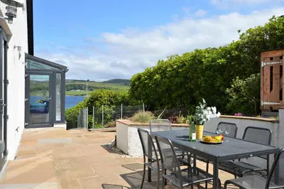 a black table and chairs on a patio at The Neuk in Tighnabruaich