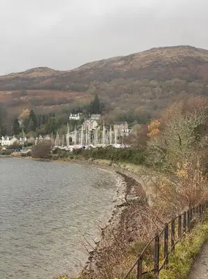 a body of water next to a hill with houses at Upper Villa, Tighnabruiach, Argyll & Bute in Tighnabruaich