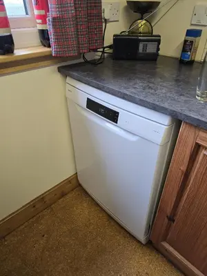 a white dishwasher in a kitchen with a counter at The Old Ferryhouse in Port Appin