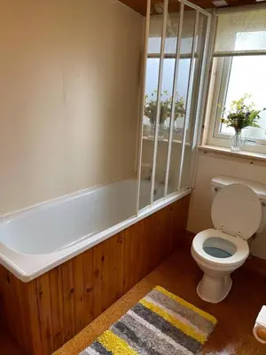 a bathroom with a toilet and a tub and a window at The Old Ferryhouse in Port Appin