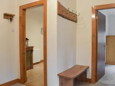 a room with a wooden bench and a door at The Lodge in Linlithgow