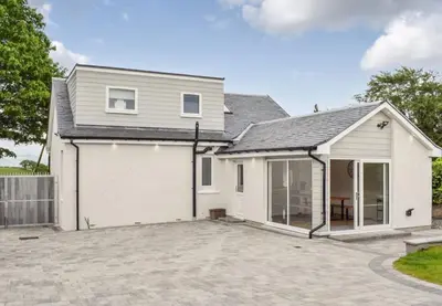 a house with a large driveway in front of it at 5 Bed cottage with Hot tub in Bannockburn