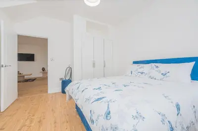 a bedroom with a bed with a blue and white bedspread at 5 Bed cottage with Hot tub in Bannockburn