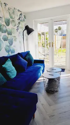 a living room with a blue couch and a table at Beautiful 2bed house with garden, walking distance to town - FREE parking in Glasgow
