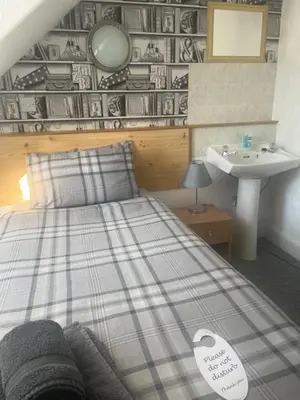 a bedroom with a bed and a sink and a sink at Dunarle Guesthouse in Oban