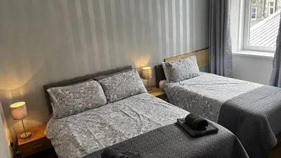 a hotel room with two beds and a window at Dunarle Guesthouse in Oban