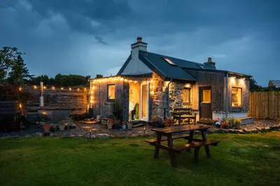 a house with a picnic table in front of it at Jura, Mrs Leonard's Cottage in Isle of Jura
