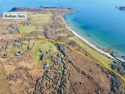 an aerial view of the shoreline with a yellow road at Jura, Mrs Leonard's Cottage in Isle of Jura