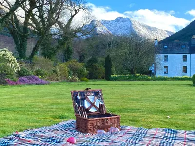 a basket of balls sitting on a blanket on a field at Ballachulish House Apartment in Ballachulish