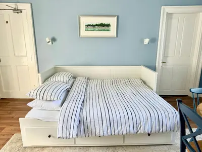 a white bed with two pillows on it in a room at Ballachulish House Apartment in Ballachulish