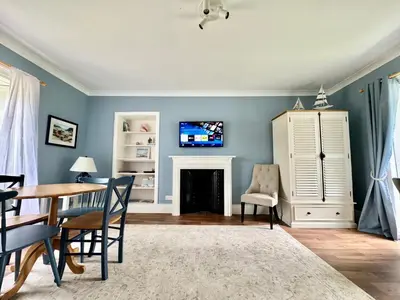 a living room with a table and a fireplace at Ballachulish House Apartment in Ballachulish