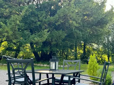 a picnic table with two chairs and a lantern at The Bothy of Ballachulish House in Ballachulish