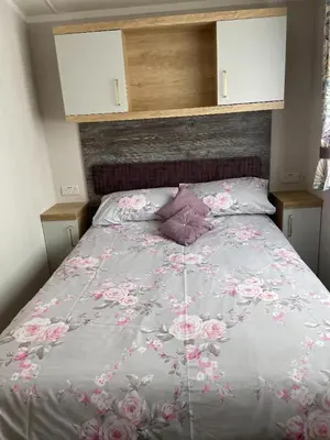 a bedroom with a bed with pink flowers on it at Swift Bordeaux 67 in Dunoon