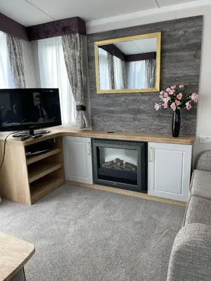 a living room with a fireplace and a television at Swift Bordeaux 67 in Dunoon