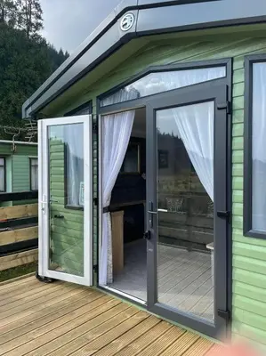a sliding glass door on a house with a deck at Swift Bordeaux 67 in Dunoon