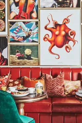 a red couch with a table with plates of food at No17 The Promenade in Oban