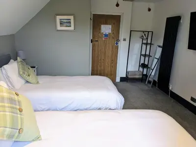 a hotel room with two beds and a door at Lochaline Hotel in Lochaline