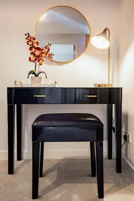 a black desk with a mirror and a plant at The Arran Suite - Your Stylish Scottish Getaway! in Glasgow