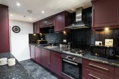 a kitchen with purple cabinets and a stove top oven at The Arran Suite - Your Stylish Scottish Getaway! in Glasgow