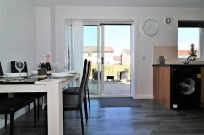a kitchen and dining room with a table and a clock at Signature - Whistleberry House in Hamilton