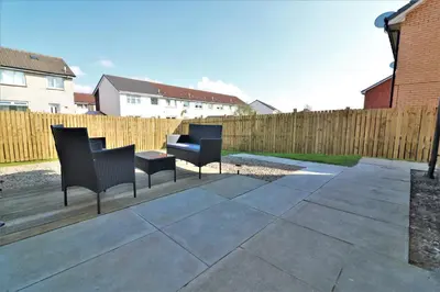 a patio with black chairs and a wooden fence at Signature - Whistleberry House in Hamilton
