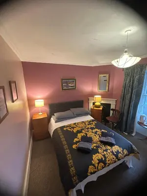 a bedroom with a bed in a room with pink walls at the CITY- Braveheart House in Edinburgh
