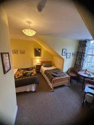 a bedroom with two beds and a table and a window at the CITY- Braveheart House in Edinburgh