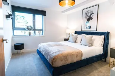 a bedroom with a large bed with a blue frame at The Lusso Suite - 2BR - A 5* Escape Like No Other in Glasgow