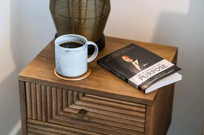 a book and a cup of coffee on a wooden table at The Lusso Suite - 2BR - A 5* Escape Like No Other in Glasgow