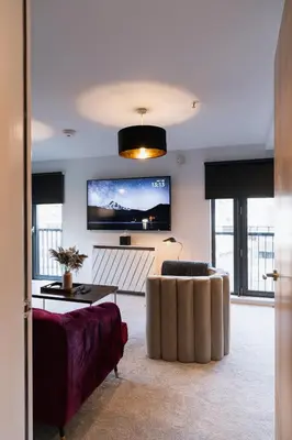 a living room with a couch and a flat screen tv at The Lusso Suite - 2BR - A 5* Escape Like No Other in Glasgow