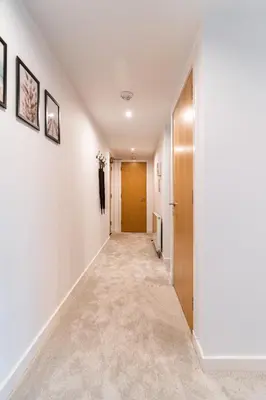 an empty hallway with white walls and a door at The Lusso Suite - 2BR - A 5* Escape Like No Other in Glasgow