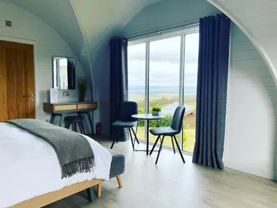 a bedroom with a bed and a table and chairs at The Vu Snugs in Bathgate