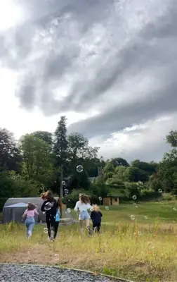 a group of people playing frisbee in a field at Luxury Rural Ayrshire Glamping Pod in Dalmellington