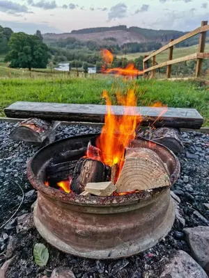 a fire pit with flames in it in a field at Luxury Rural Ayrshire Glamping Pod in Dalmellington