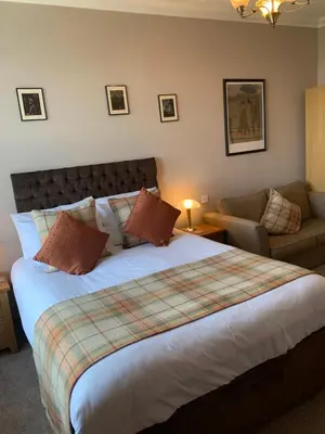 a bedroom with a large bed and a couch at The Apartment - Chandlers in Ascog