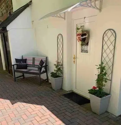 a patio with a bench and two potted plants at The Apartment - Chandlers in Ascog