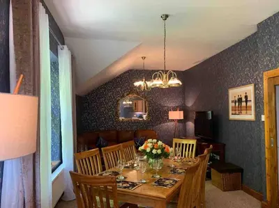 a dining room with a table with flowers on it at The Apartment - Chandlers in Ascog