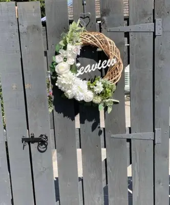 a wreath on a wooden fence with a sign on it at Seaview Cottage Bute in Ascog