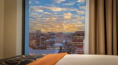 a view of a city from a bedroom window at Clayton Hotel Glasgow City in Glasgow