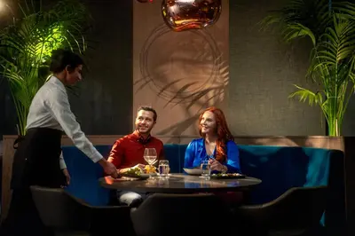 a man and woman sitting at a table in a restaurant at Clayton Hotel Glasgow City in Glasgow