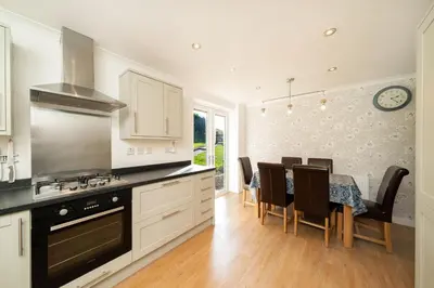 a kitchen with a table and a dining room at Lagnaha Cottage in Kentallen