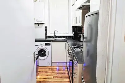 a kitchen with a stove and a sink and a dishwasher at Glasgow Southside: Cosy 2 Bedroom Apartment in Glasgow