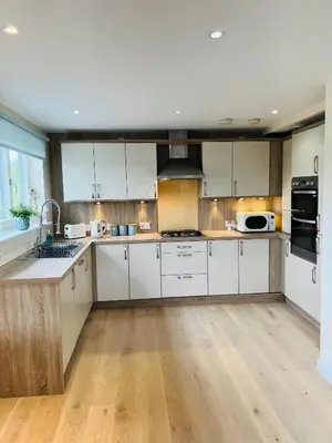 a large kitchen with white cabinets and a sink at Riverside View Penthouse in Balloch, Loch Lomond in Balloch