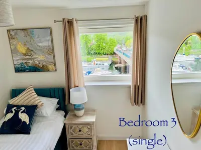 a bedroom with a window and a bed and a mirror at Riverside View Penthouse in Balloch, Loch Lomond in Balloch