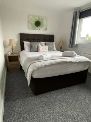 a bedroom with a large bed with two pillows on it at Pure Apartments Fife - Dunfermline West in Oakley
